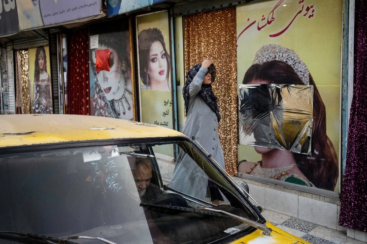 Una mujer pasa junto a salones de belleza en Kabul, Afganistán. Foto Ap / Archivo