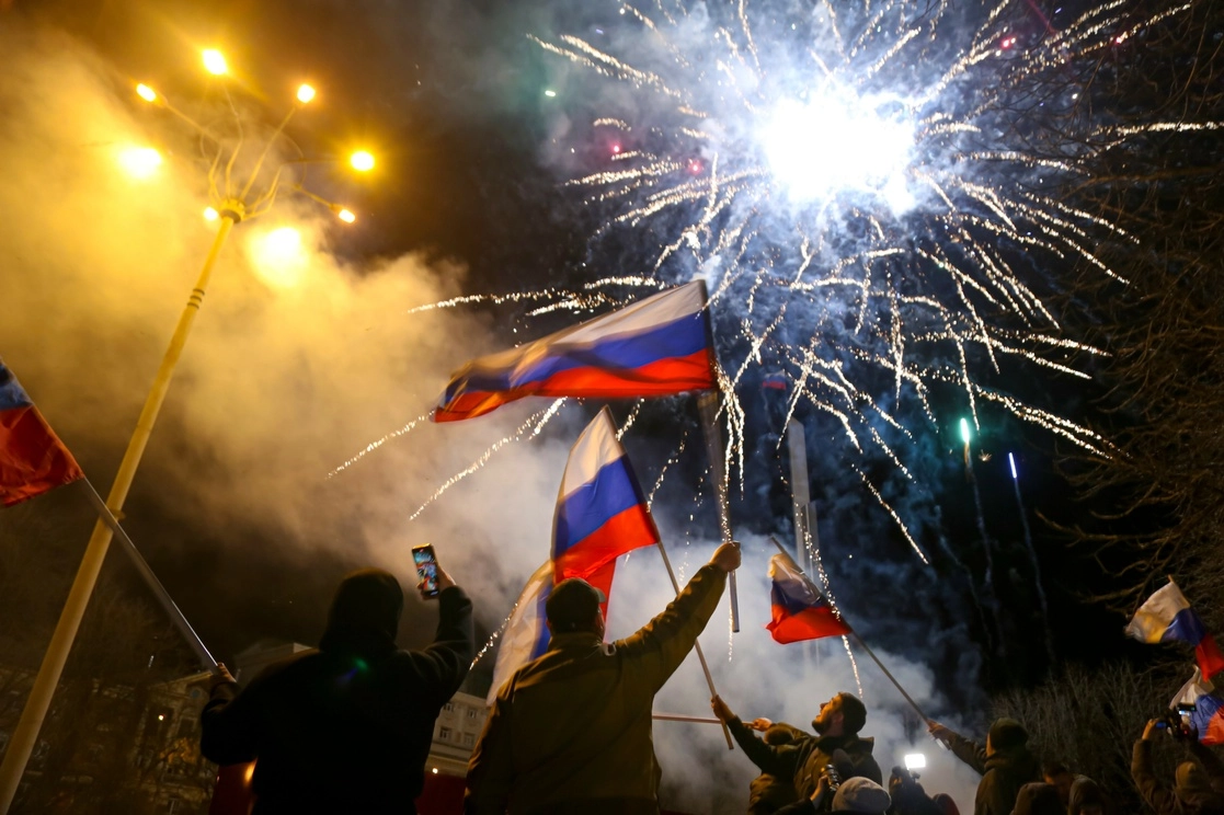 La gente ondea banderas nacionales rusas celebrando el reconocimiento de la independencia en el centro de Donetsk, el territorio controlado por militantes prorrusos, en el este de Ucrania. Foto Ap