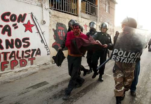 Imagen del 4 de mayo de 2006 en la que un poblador de San Salvador Atenco, sangrando visiblemente, es detenido por elementos de la policía estatal. Foto Alfredo Domínguez
