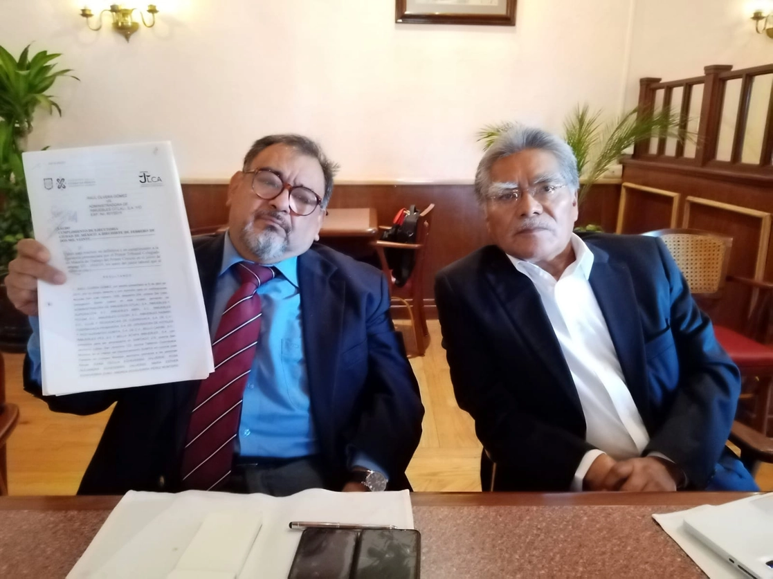  Los abogados de  Raúl Olvera Gómez, ex contador de las empresas de la familia Echeverría, Heraclio Bonilla Gutiérrez (der) y Marco Antonio Sánchez Hernández (izq), quien muestra el documento, el 13 de septiembre de 2021. Foto César Arellano
