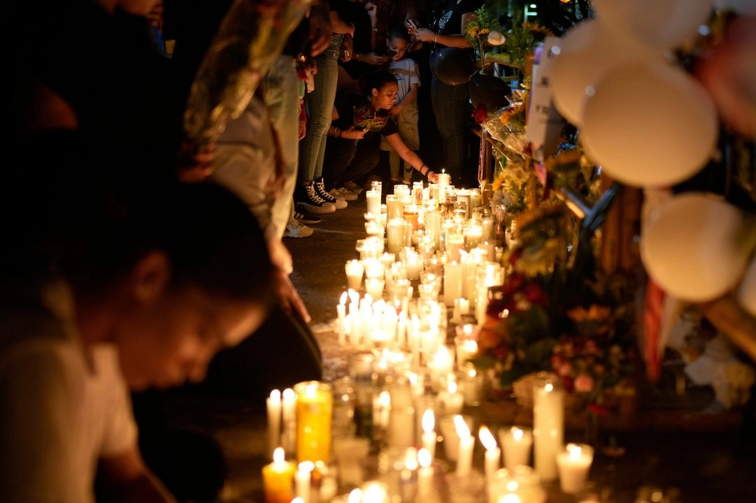 La gente enciende velas en un monumento improvisado afuera del club nocturno Jet Set, en memoria de las más de 200 personas que murieron cuando se derrumbó su techo, en Santo Domingo, República Dominicana, el viernes 11 de abril de 2025.