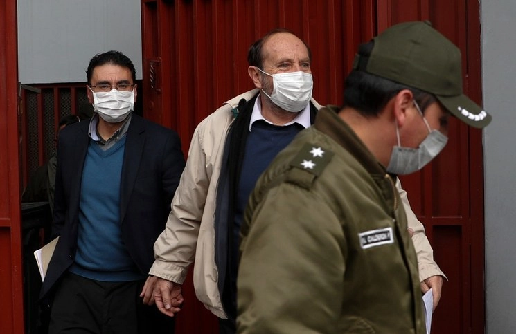 El ex ministro de Salud de Bolivia, Marcelo Navajas (centro) es escoltado a una audiencia en la corte de La Paz, Bolivia. Foto Ap