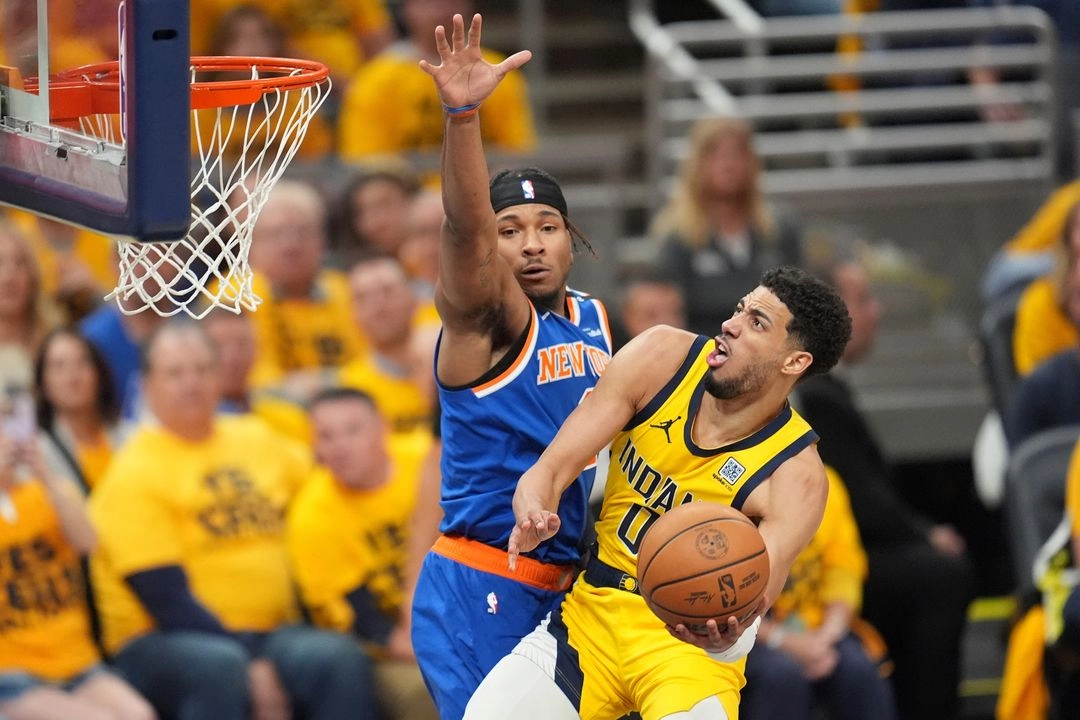 El base de los Indiana Pacers, Tyrese Haliburton (0), lanza el balón superando al base de los New York Knicks, Miles McBride (izquierda), durante el cuarto partido de las finales de la Conferencia Este. Foto