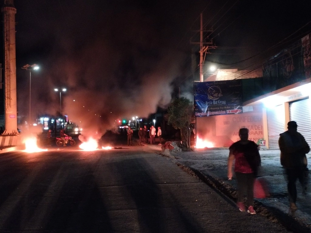 La tarde del jueves, familiares, amigos y vecinos de las víctimas bloquearon la circulación de la carretera México Tuxpan cerca del hospital general de Tulancingo con vehículos atravesados y con neumáticos a los que prendieron fuego, todo ello ante las versiones de que Luis Esteban era influyente y sería liberado. Foto Ricardo Montoya 