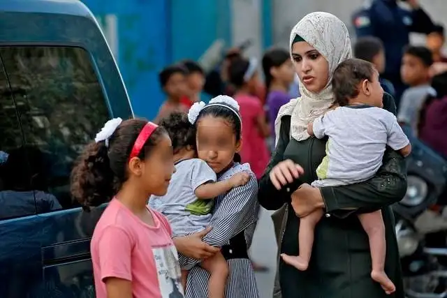 La normalización de las relaciones entre Israel y los Emiratos Árabes Unidos "no ayuda a la causa palestina", señaló Hamas. En la imagen, una madre palestina recoge a sus hijos de la escuela en Gaza. Foto Afp 
