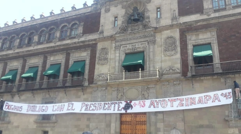 Un grupo de jóvenes con el rostro cubierto saltó las vallas metálicas que rodean Palacio Nacional y, sobre la fachada justo debajo del balcón presidencial, colgó el lienzo con el mensaje: “Exigimos diálogo con el Presidente. + 43 Ayotzinapa”, el 1 de marzo de 2024. Foto Jared Laureles 