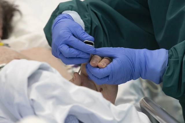 Una enfermera ajusta el oxímetro en un paciente con coronavirus, en la unidad de terapia intensiva en Roma, Italia. Foto Ap 