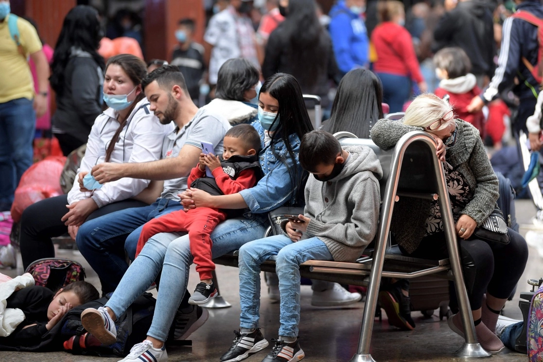 Personas esperan para comprar un boleto de autobús en la terminal de Bogotá, en Colombia, el 31 de diciembre de 2021. Foto Afp 