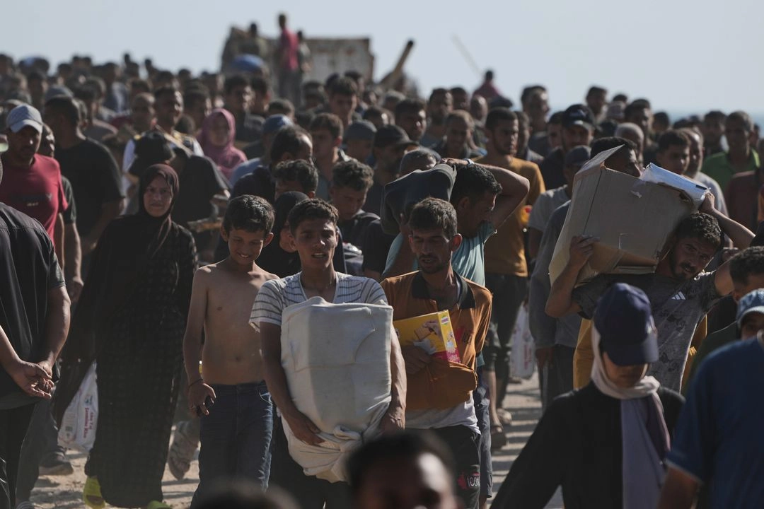 Palestinos llevan cajas con alimentos y paquetes de ayuda humanitaria entregados por la Fundación Humanitaria de Gaza, una organización respaldada por Estados Unidos y aprobada por Israel, en Rafah, en el sur de la Franja de Gaza, el 27 de mayo de 2025.