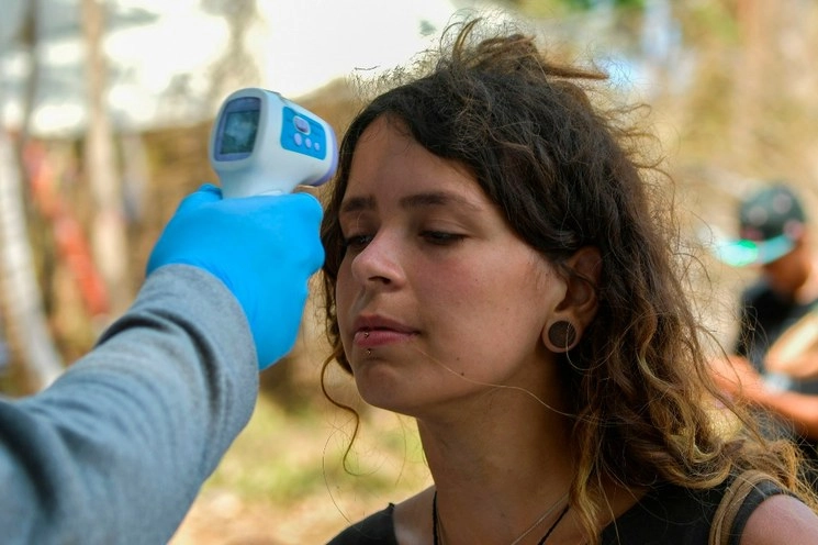 A una joven le toman la temperatura en Panamá. Foto Afp