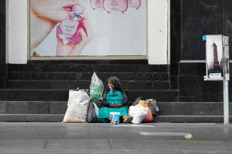 Una mujer en situación de calle, sentada sobre la banqueta de avenida Juárez, casi esquina con el Eje Central, durante la Fase 3 de la pandemia por Covid-19 en la Ciudad de México, el 11 de julio de 2020. Foto Pablo Ramos