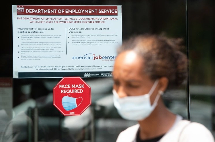 Una mujer sale de una oficina del Departamento de Servicios de Empleo de Estados Unidos, donde se tramitan beneficios por desocupación, en Washington, DC, el 16 de julio de 2020. Foto Afp
