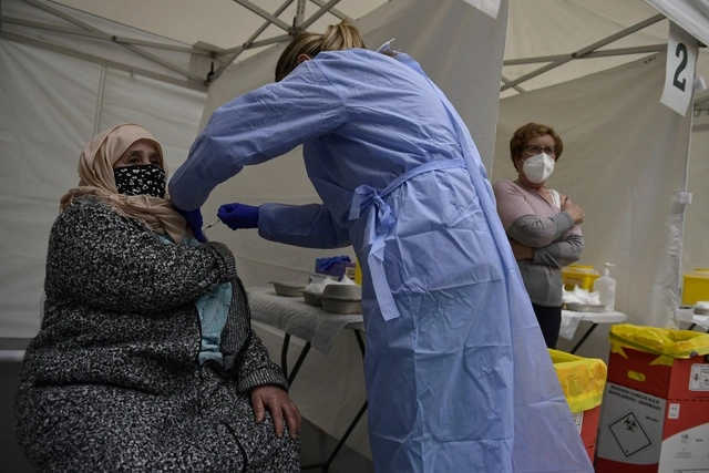 Una trabajadora de salud vacuna a una ciudadana marroquí residente en España. Foto Ap / Archivo