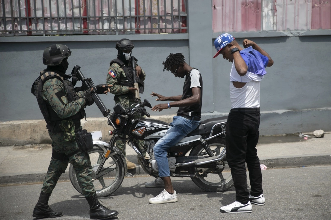 Las fuerzas armadas de Haití revisan a dos hombres que conducían una motocicleta en busca de armas, en el área de las oficinas estatales de Puerto Príncipe. Foto Ap / Archivo 