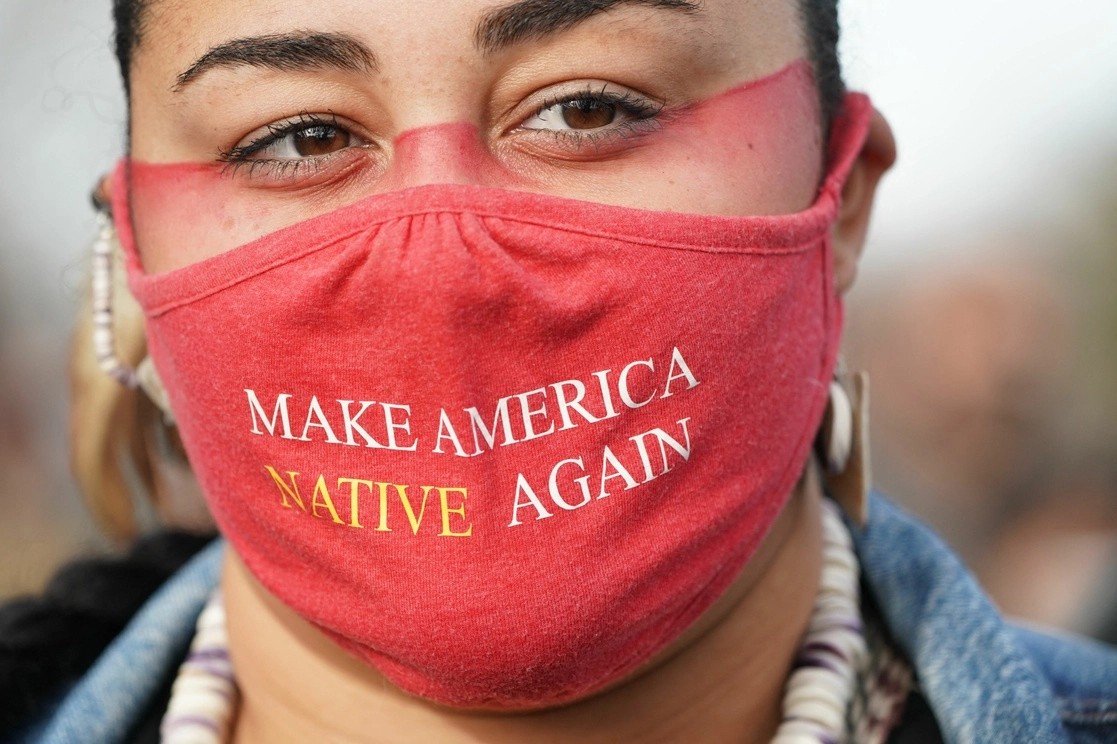 Micah Stasis lleva una máscara con el mensaje "Hacer a Estados Unidos Nativo de Nuevo", durante el Día Nacional de Luto (Acción de Gracias), en Plymouth, Massachusetts, el 25 de noviembre de 2021. Foto Afp