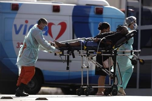 Trabajadores de salud trasladan a un paciente con sospecha de estar infectado con Covid-19 en un hospital de Brasilia, Brasil. Foto Ap