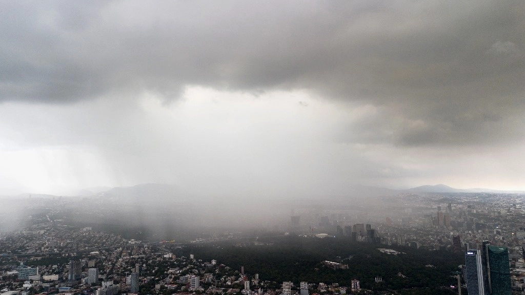 La fuerte precipitación pluvial de la tarde de ayer, que azotó principalmente zonas de la alcaldía Tláhuac, ocasionó inundaciones hasta de 35 cm de altura en avenidas y calles, así como autos varados y la caída de árboles en otros puntos de la capital. En la imagen, vista de Chapultepec y Polanco desde la colonia Roma. Foto Pablo Ramos