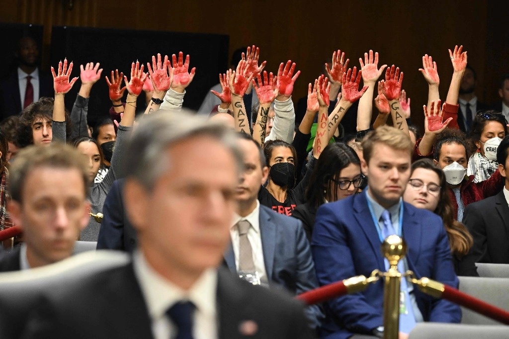 “¡Dejen de financiar el genocidio en Gaza! ¡Alto el fuego ya! ¡los palestinos no son animales! ¡vergüenza debería darles!”, gritaron manifestantes en el congreso de Estados Unidos cuando el secretario de estado, Antony Blinken (en primer plano), y el secretario de defensa, Lloyd Austin, argumentaron que el país debe enviar inmediatamente ayuda a Israel y Ucrania. Los activistas levantaron las manos manchadas de rojo para simbolizar la sangre derramada en la asediada franja. Foto Afp 