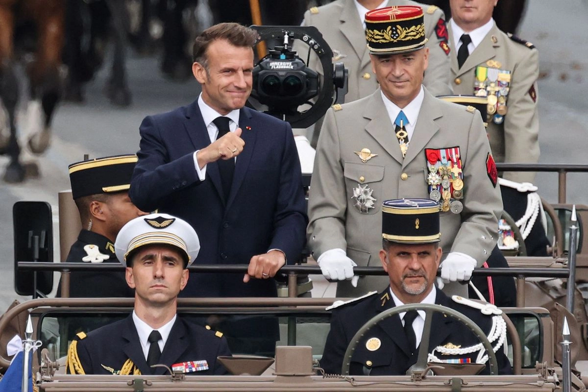 El presidente de Francia, Emmanuel Macron (izq.), y el jefe del Estado Mayor de la Defensa, general Thierry Bukhard (der.), pasan revista a las tropas en el vehículo de mando durante el desfile militar anual del Día de la Bastilla en la avenida de los Campos Elíseos de París, el 14 de julio de 2025.