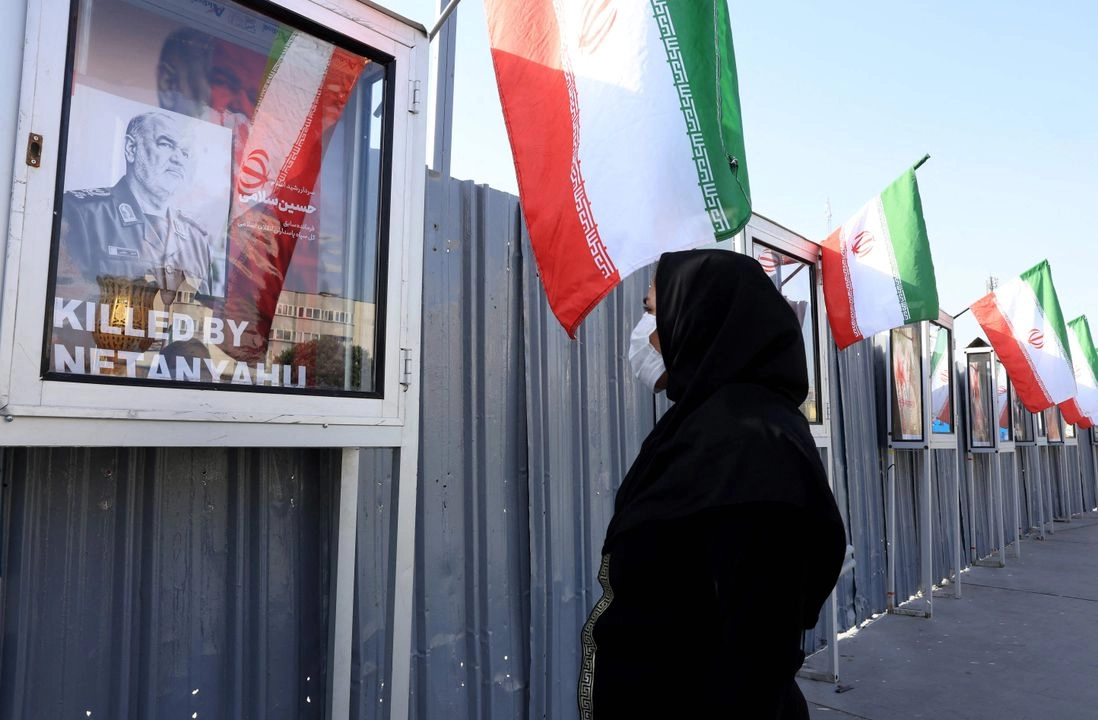 Una mujer iraní observa la imagen del jefe del Cuerpo de la Guardia Revolucionaria Islámica (CGRI) de Irán, Hossein Salami, en un monumento conmemorativo a los caídos a manos de Israel, en la plaza Hafteh-tir de Teherán, el 23 de junio de 2025. Foto