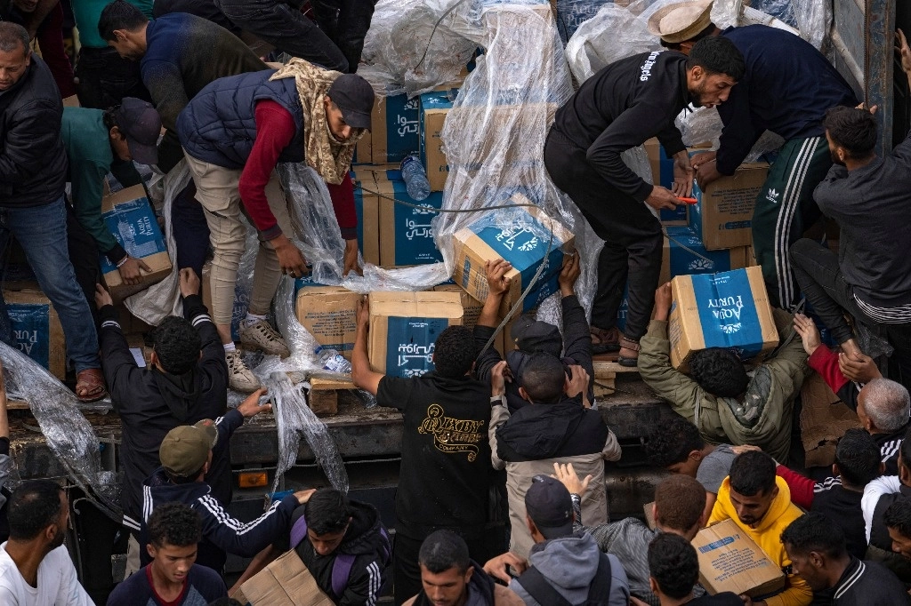 Palestinos saquean un camión con ayuda humanitaria que se movilizaba hacia la Franja de Gaza en Rafah. Foto Ap