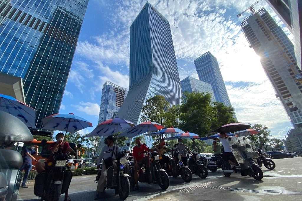 Un grupo de conductores de motocicletas eléctricas espera a que cambie el semáforo en Shenzhen, China. La ciudad se ha convertido en un laboratorio para el uso de la inteligencia artificial, las redes 5G y el ‘big data’ lo mismo en actividades cotidianas que en la administración pública y los servicios urbanos. Foto Ap