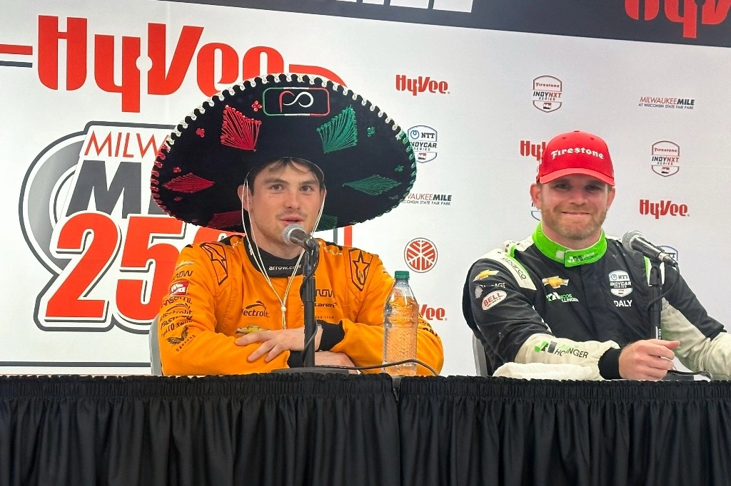Pato O'Ward, de México, a la izquierda, usa un sombrero en la conferencia de prensa posterior a la carrera de autos IndyCar en Milwaukee Mile en West Allis, Wisconsin, el sábado 31 de agosto de 2024. Foto Ap