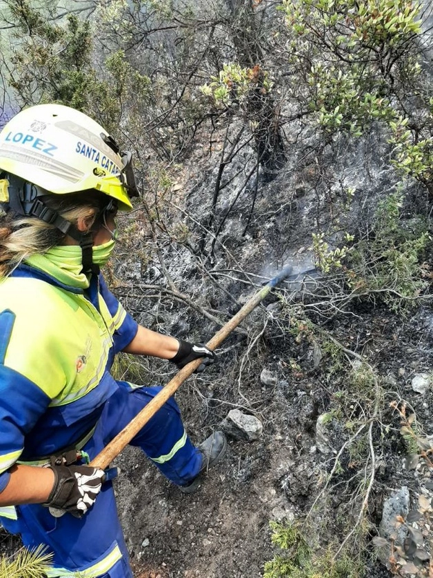 Una brigadista ayuda a apagar uno de los incendios. Foto Protección Civil