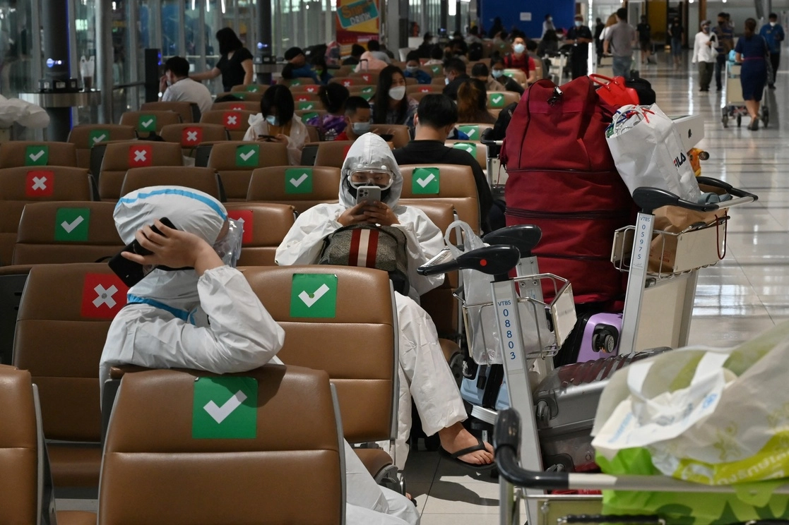 Pasajeros usan trajes de protección contra el Covid-19 en el aeropuerto Suvarnabhumi en Bangkok, Tailandia, el 30 de junio de 2021. Foto Afp