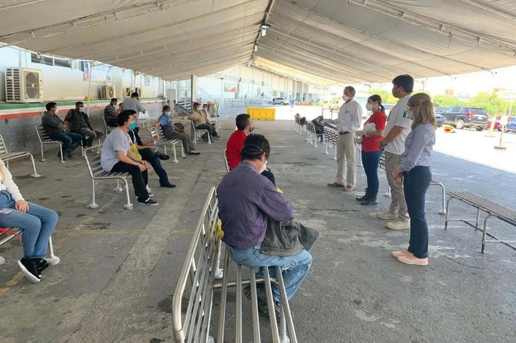 Personal del ITM dando indicaciones a las personas repatriadas. Foto La Jornada