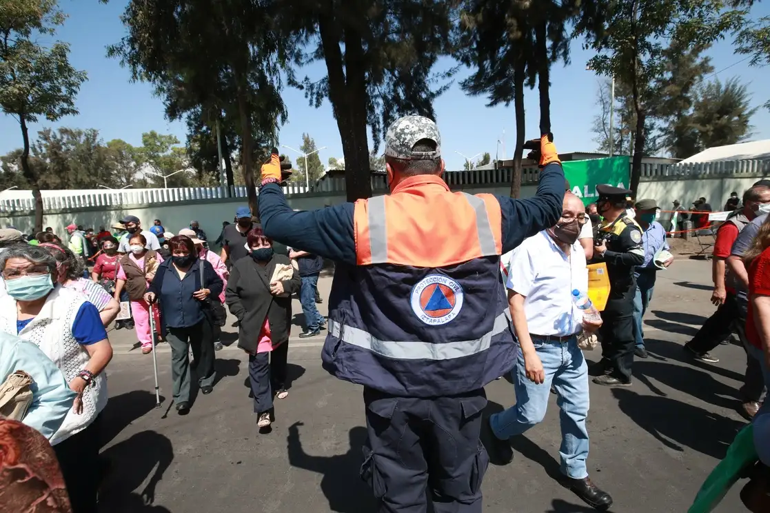Personal de Protección Civil de la alcaldía Iztapalapa controla el flujo vial para que adultos mayores, ya inoculados contra el Covid-19, puedan atravesar la avenida Canal de Garay, donde se encuentra el módulo de vacunación de la Unidad Militar El Vergel, en la Ciudad de México, el 6 de abril de 2021. Foto Luis Castillo