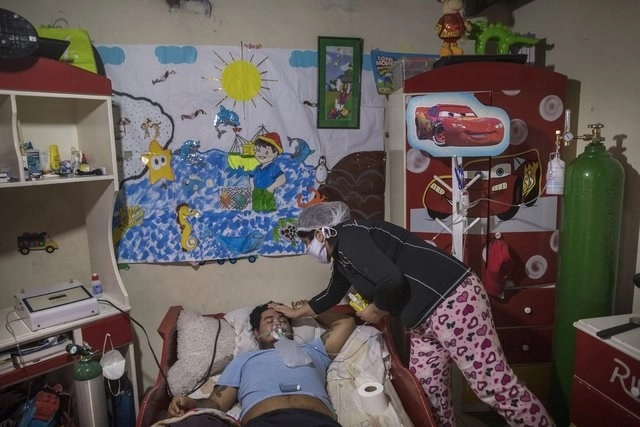Joven con Covid-19 es atendido por su esposa en Lima, Perú; la nación sudamericana acumula 46 mil defunciones. Foto Ap/Archivo