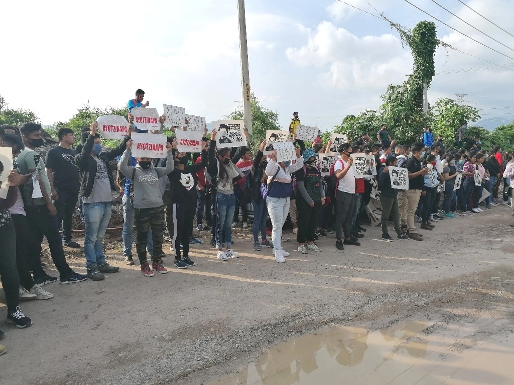 Mujeres normalistas, muchas de ellas llorando, hacen valla a los padres de familia portando fotos de los estudiantes desaparecidos. Fotos Sergio Ocampo. 
