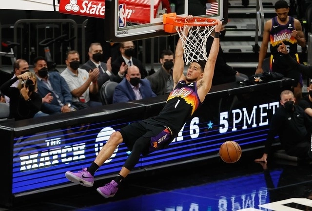 Devin Booker de los 'Suns' de Phoenix encesta una canasta durante el juego. Foto Afp