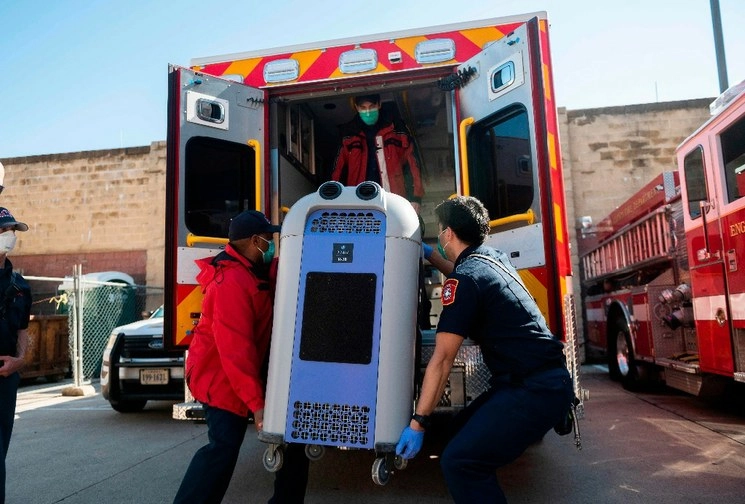 Paramédicos cargan una máquina descontaminante en una ambulancia, afuera de un hospital en Arlington, Virginia, Estados Unidos. Foto AFP 