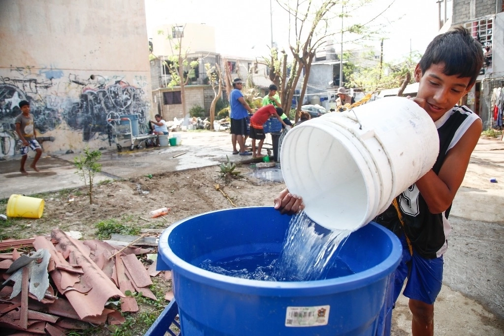 Un joven recolecta agua potable en la alcaldía Venustiano Carranza. Foto Victor Camacho / Archivo