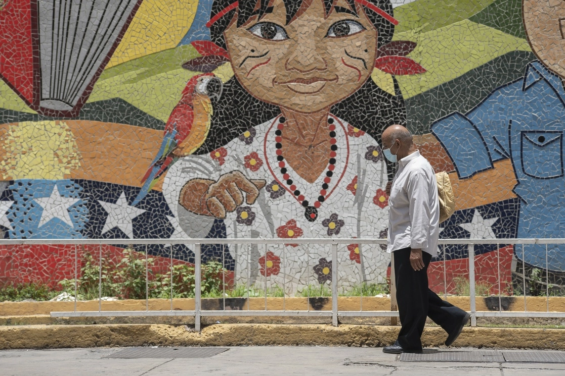 Un hombre camina frente a un mural, en Caracas, Venezuela, el 11 de mayo de 2021. Foto Xinhua