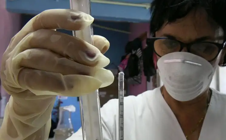 Una trabajadora revisa la temperatura del alcohol que se emplea en el procesamiento de gel antibacterial producido en la Destilería Habana, en La Habana, Cuba. Foto Xinhua
