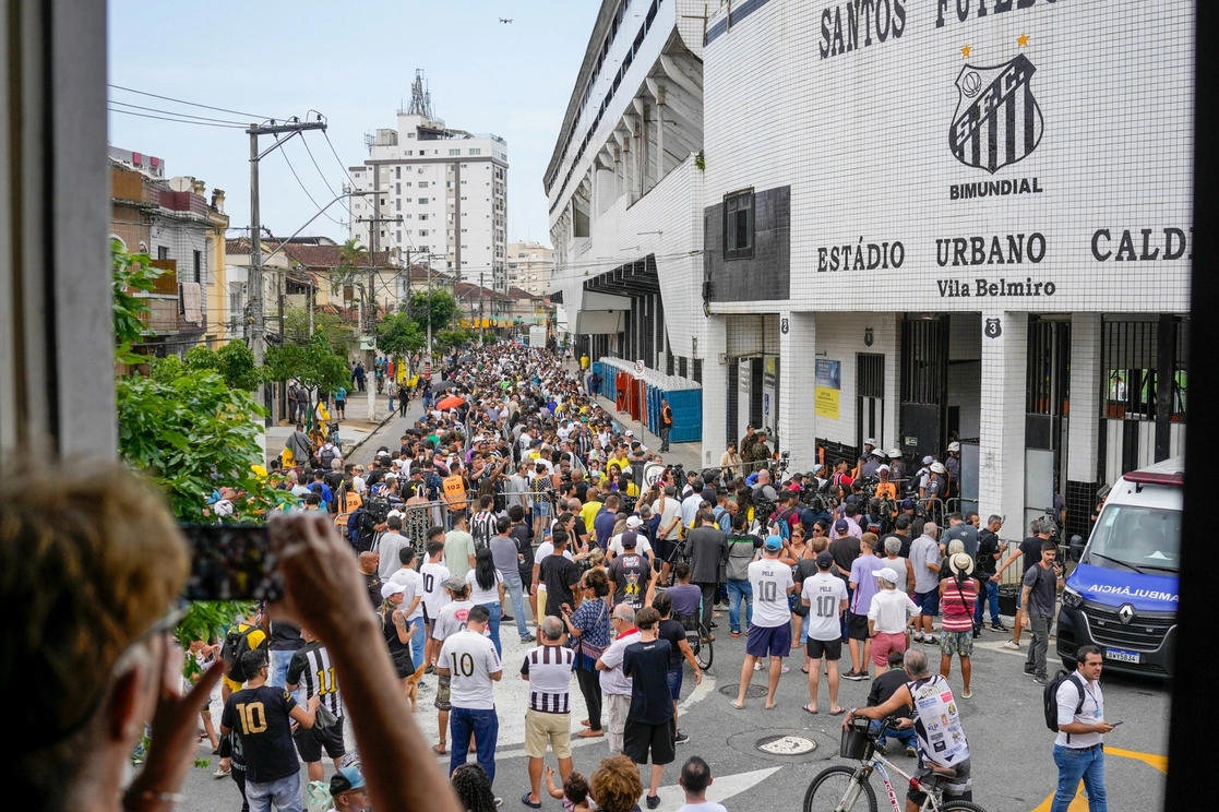La gente hace fila para presentar sus últimos respetos al difunto gran futbolista brasileño Pelé en el estadio Vila Belmiro donde yace su cuerpo en Santos, Brasil, el lunes 2 de enero de 2023. Foto Ap
