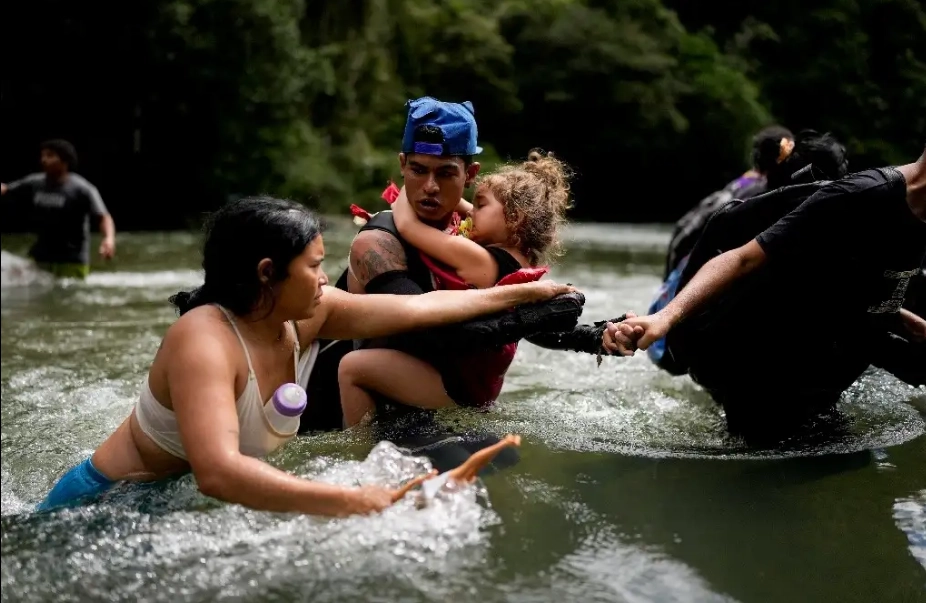 Migrantes cruzan un río cerca de Bajo Chiquito, en Panamá, después de cruzar el Darién desde Colombia. 
