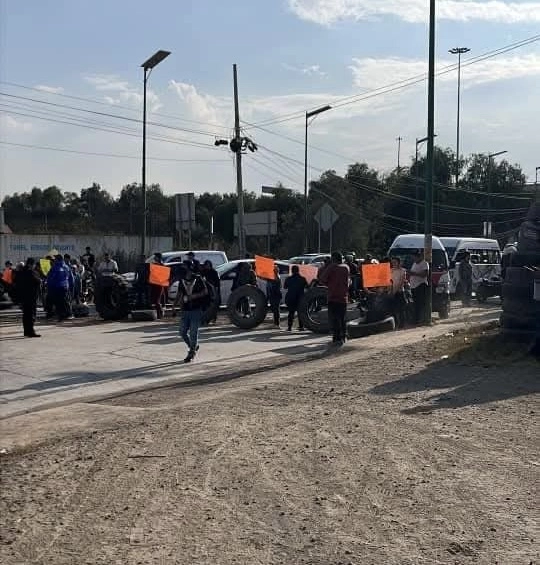 Aspectos del bloqueo para exigir que se busque a un joven que cayó en canal de aguas negras en Nextlalpan, Edomex. Foto Javier Salinas