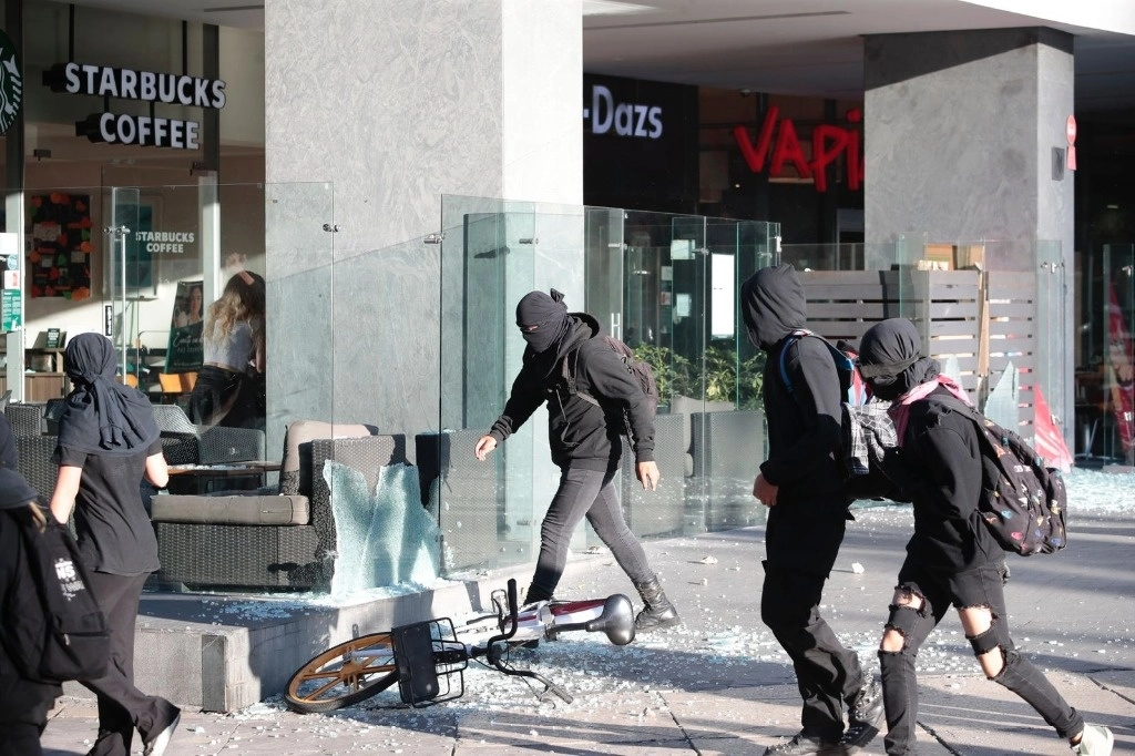 Jóvenes encapuchados realizan destrozos durante la marcha por el 9 aniversario de Ayotzinapa. Foto Luis Castillo