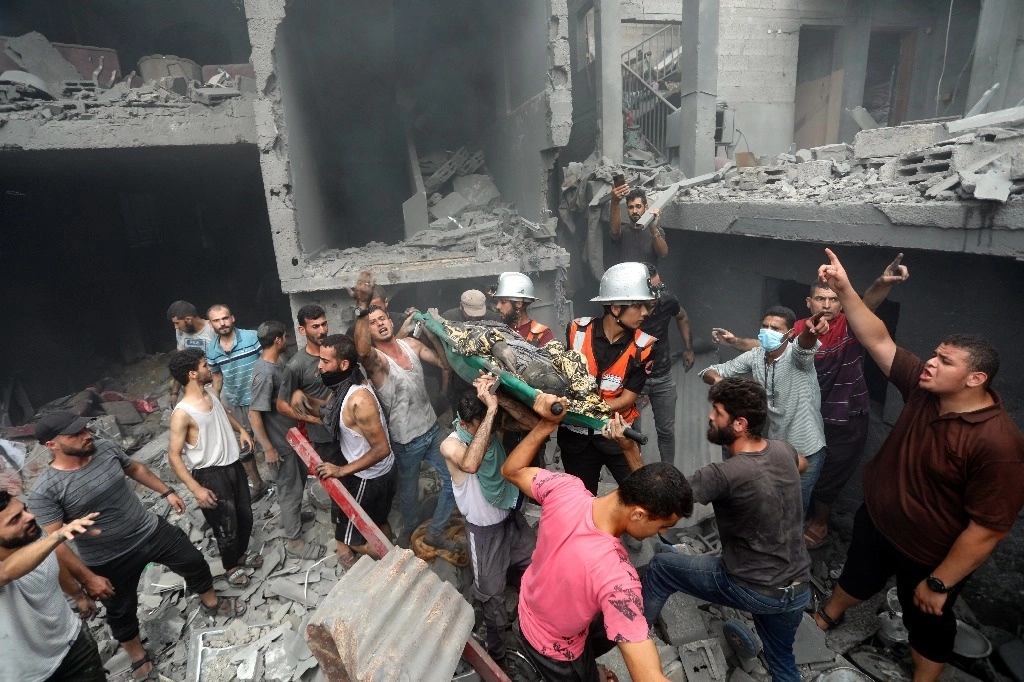 Palestinos cargan a una persona fallecida que fue encontrada entre los escombros tras los ataques aéreos israelíes en la ciudad de Gaza, el viernes 27 de octubre de 2023. Foto Ap