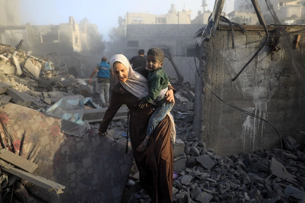 Palestinos huyen de los bombardeos aéreos israelíes en un campo de refugiados en la franja de Gaza. Foto Afp 