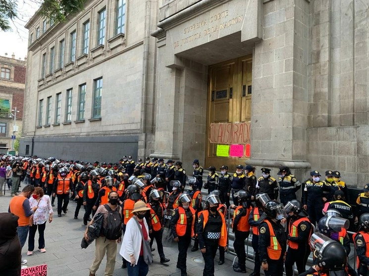 Policías del agrupamiento Atenea, quienes portan chalecos naranja, montan guardia frente a la puerta principal de la SCJN durante la marcha pro aborto del 31 de julio. Foto José Antonio López