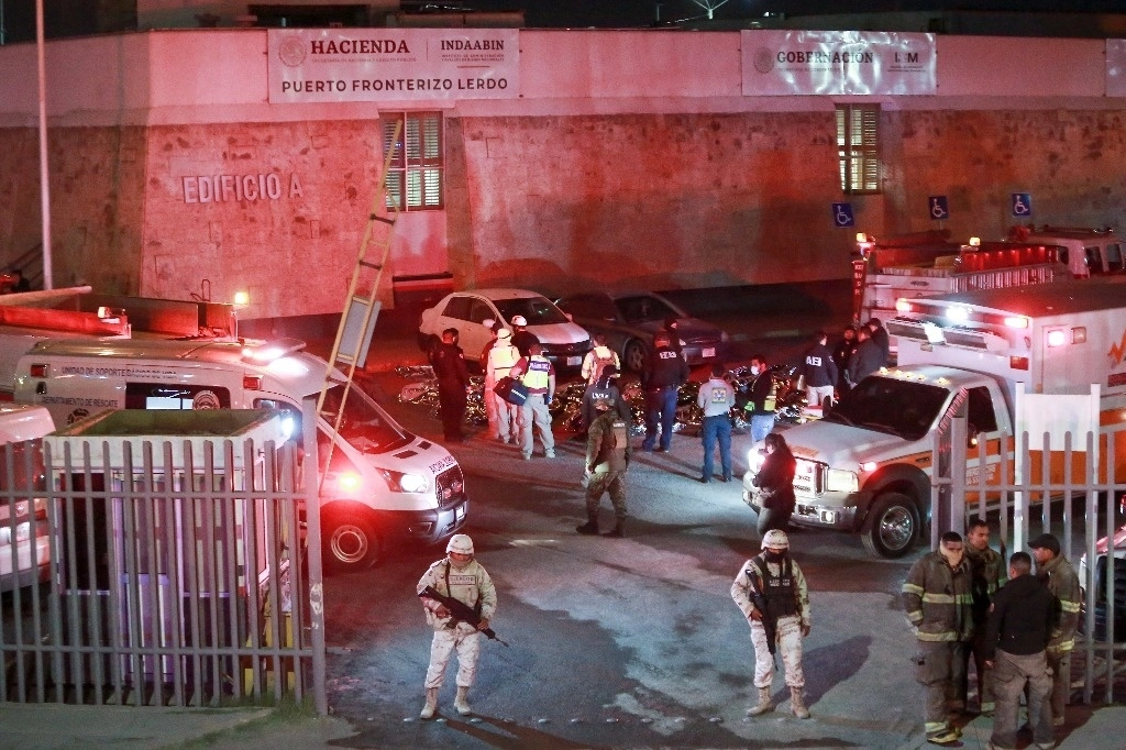 Paramédicos y fuerzas de seguridad, en medio de los cadáveres cubiertos de los migrantes que fallecieron en un albergue en Ciudad Juárez, Chihuahua, debido a un incendio. Foto Ap / Archivo