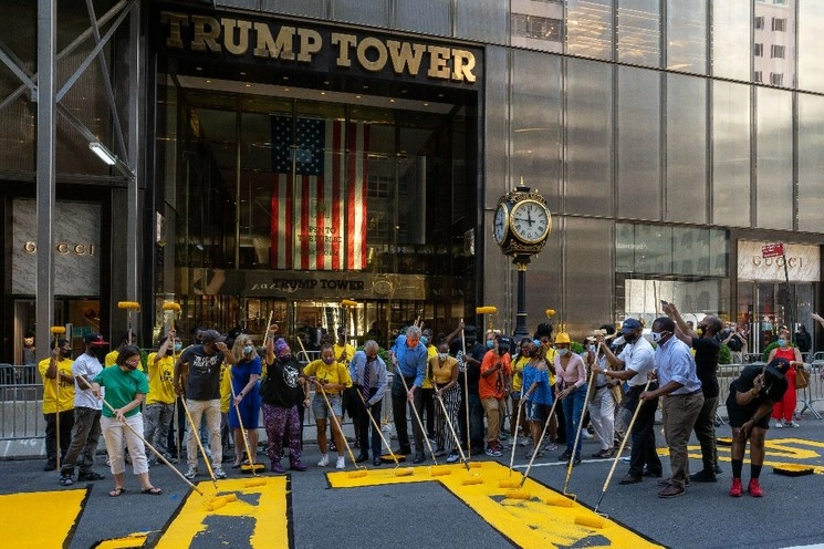 En la puesta de la leyenda, con enormes letras amarillas sobre la icónica Quinta Avenida de Nueva York, participó el alcalde Bill de Blasio (al centro). Foto Afp