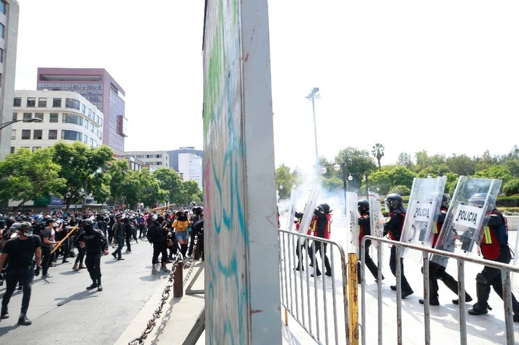 Jóvenes encapuchados marcharon del Ángel de la Independencia al Zócalo en protesta por la agresión que sufrió una menor el viernes pasado por parte de policías. Se registraron saqueos de locales y destrozos de ventanas. Foto Alfredo Domínguez