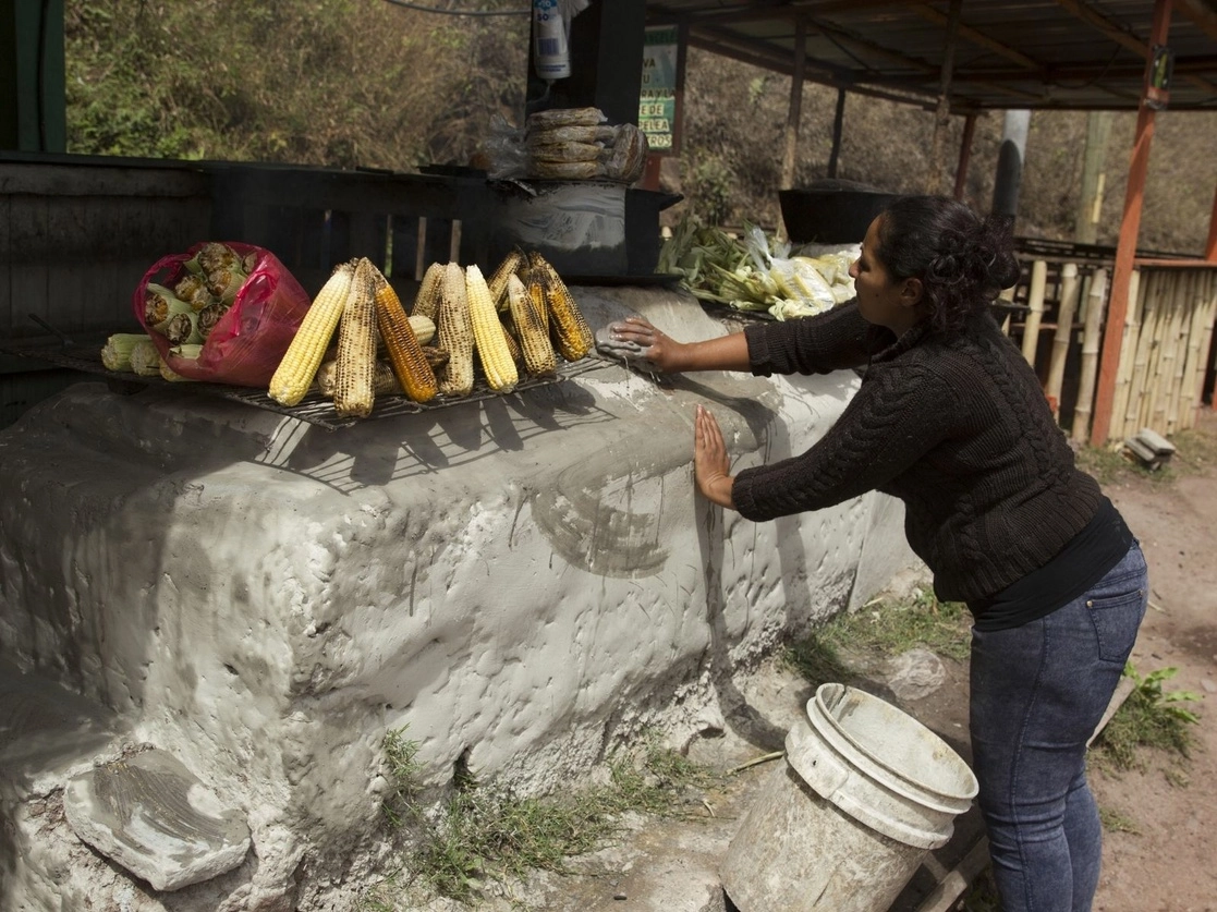 Una mujer limpia el fogón donde prepara elotes y postres tradicionales de maíz para su venta en la comunidad de Quebrada Honda, Honduras, el 22 de febrero de 2021. Foto Xinhua 