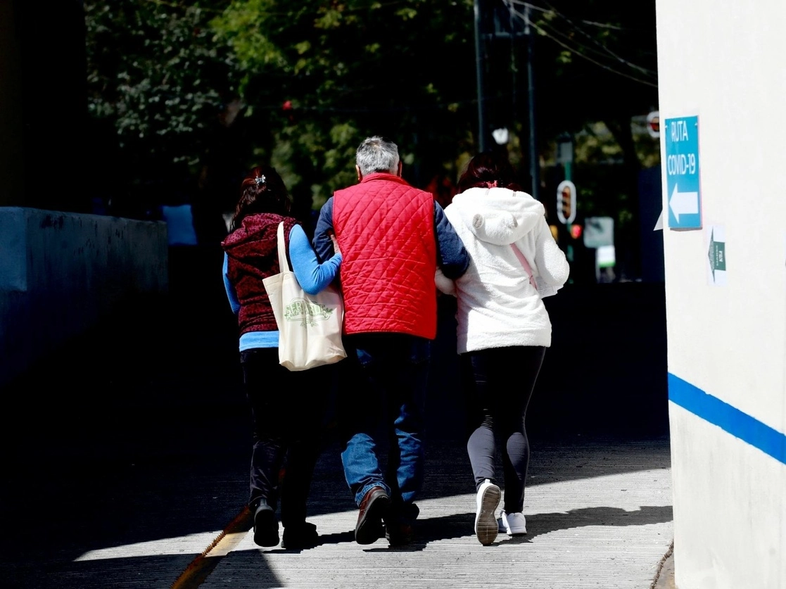 Familiares ayudan a un hombre mayor de edad a caminar mientras se dirigen al área de urgencias del Hospital General de Zona 1-A "Venados" durante la emergencia sanitaria por Covid-19, en la Ciudad de México, el 3 de febrero de 2021. Foto Luis Castillo